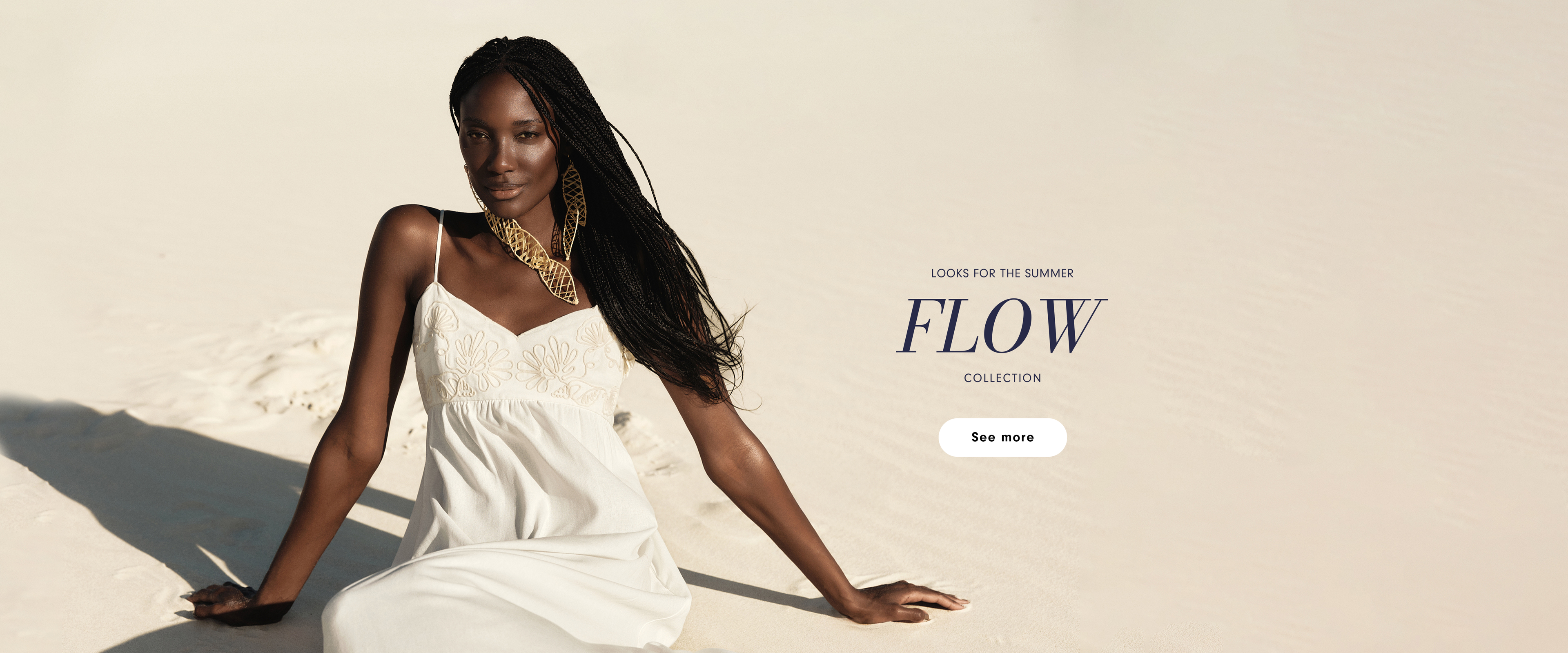 Dress To Flow Collection desktop homepage banner featuring a model in a white dress on a sandy background with the text Looks for the Summer and a See More button