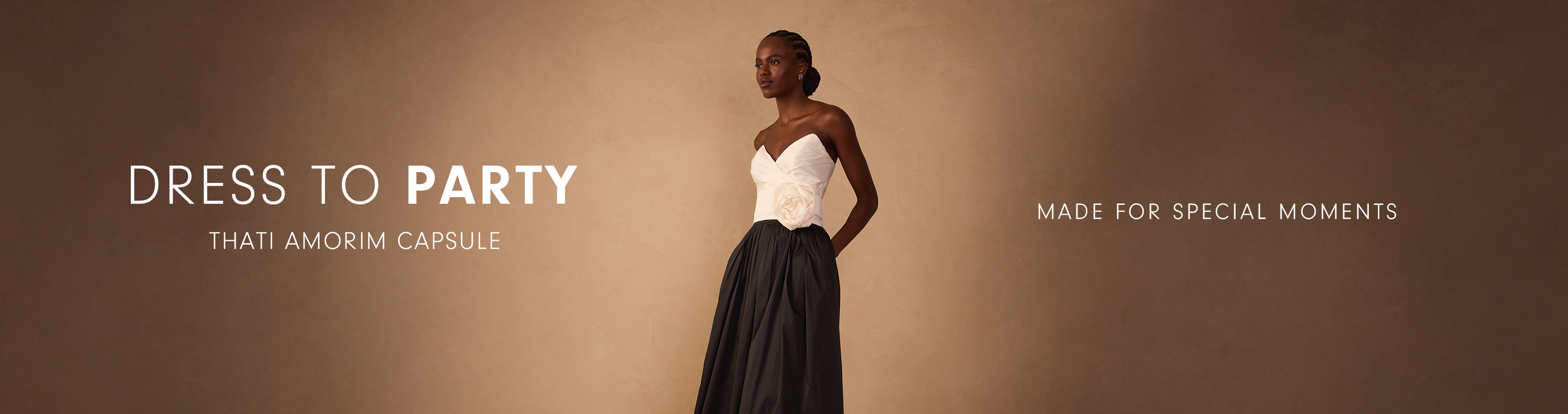 A woman wearing a formal gown with a white strapless top and a full black skirt. To her left is text overlay reading "DRESS TO PARTY", "THATI AMORIM CAPSULE", and "MADE FOR SPECIAL MOMENTS".