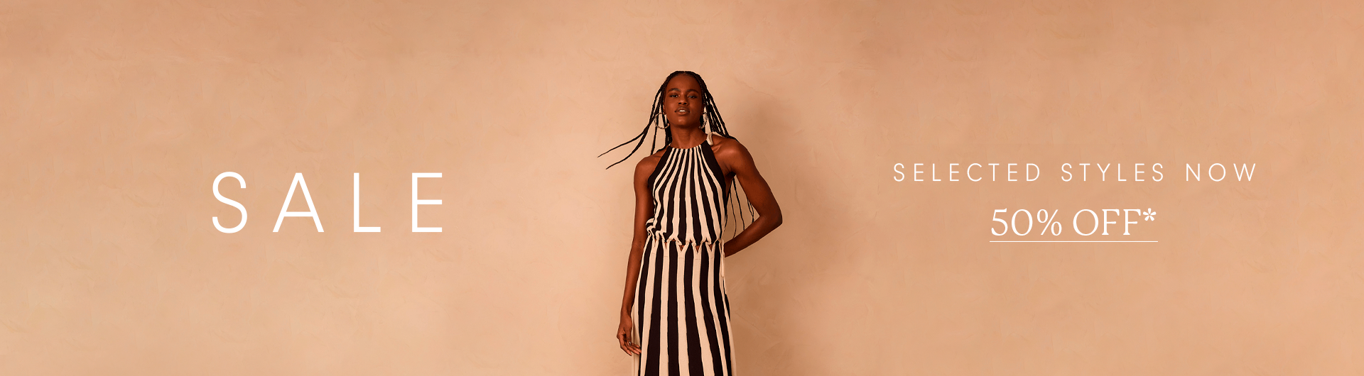 Banner desktop de SALE com modelo em vestido listrado preto e branco e oferta de 50% off em estilos selecionados.