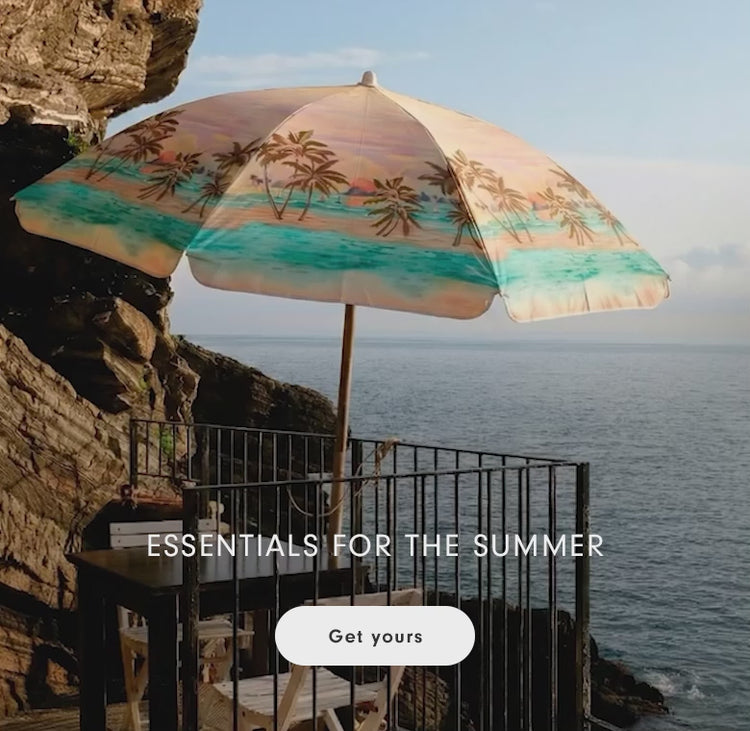Beach scene with a decorative palm tree umbrella overlooking the ocean, with the text "Essentials for the Summer"